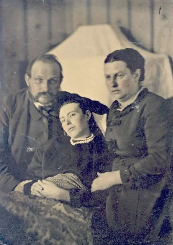 Victorian_era_post-mortem_family_portrait_of_parents_with_their_deceased_daughter-723x1024