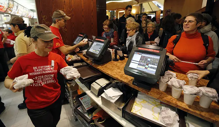 McDonald's staff members serve hamburgers at their fast food restaurant downtown Milan