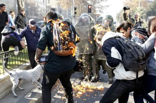 Protesters are hit by a petrol bomb during a demonstration in downtown Santiago