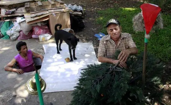 Restrepo, and wife Garcia make Christmas ornaments outside their sewer home in Medellin