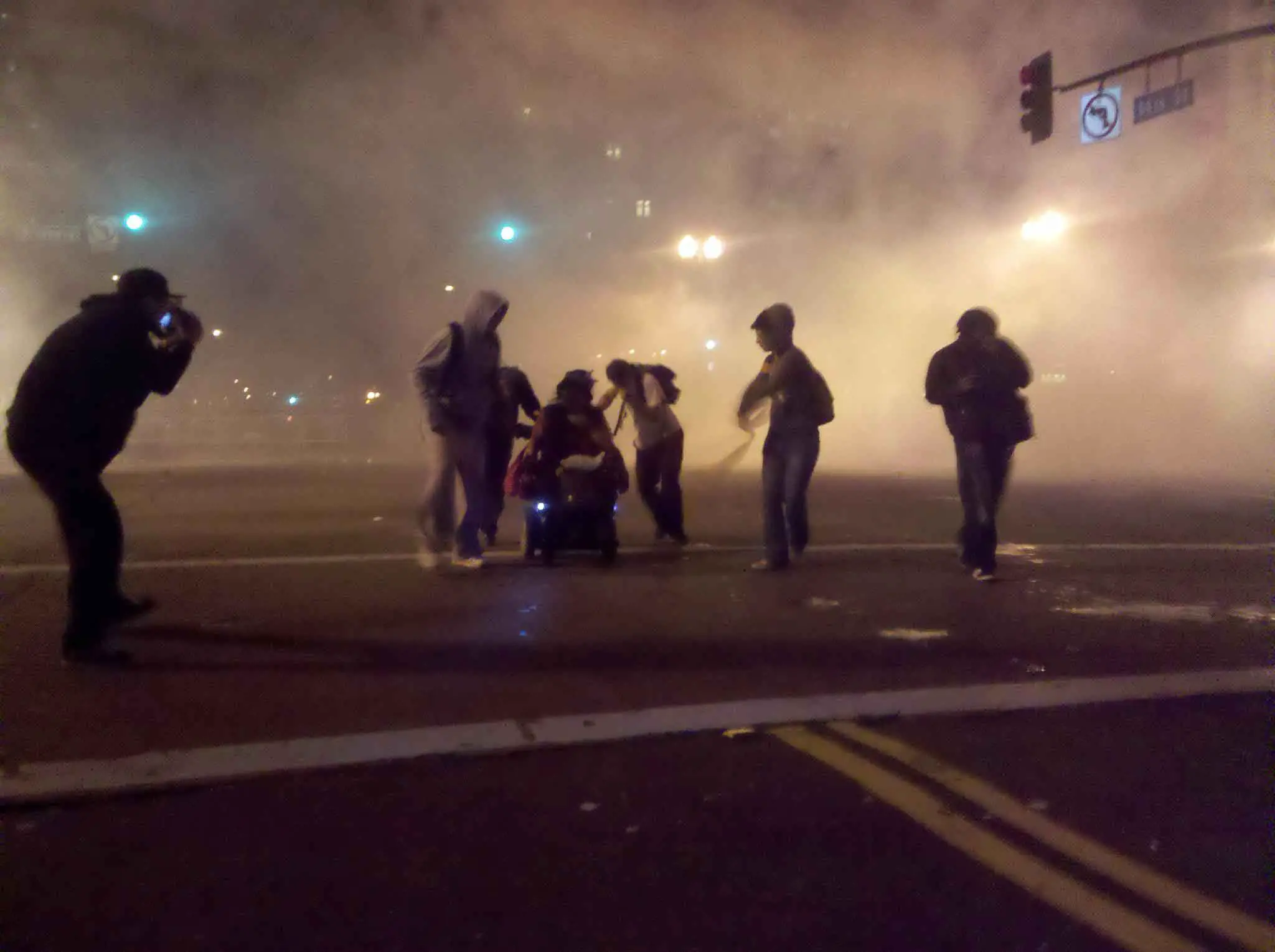 Manifestantes-ayudan-a-una-mujer-en-una-silla-de-ruedas-a-escapar-del-gas-lacrimógeno.-Oakland-EEUU-2011.